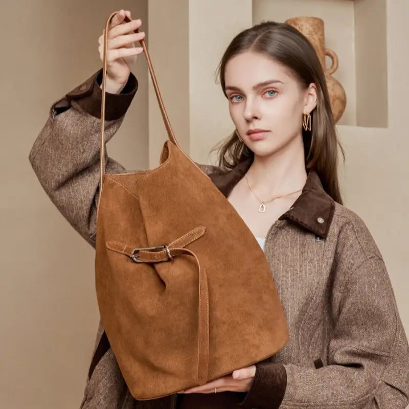 Woman holding a brown leather hobo bag