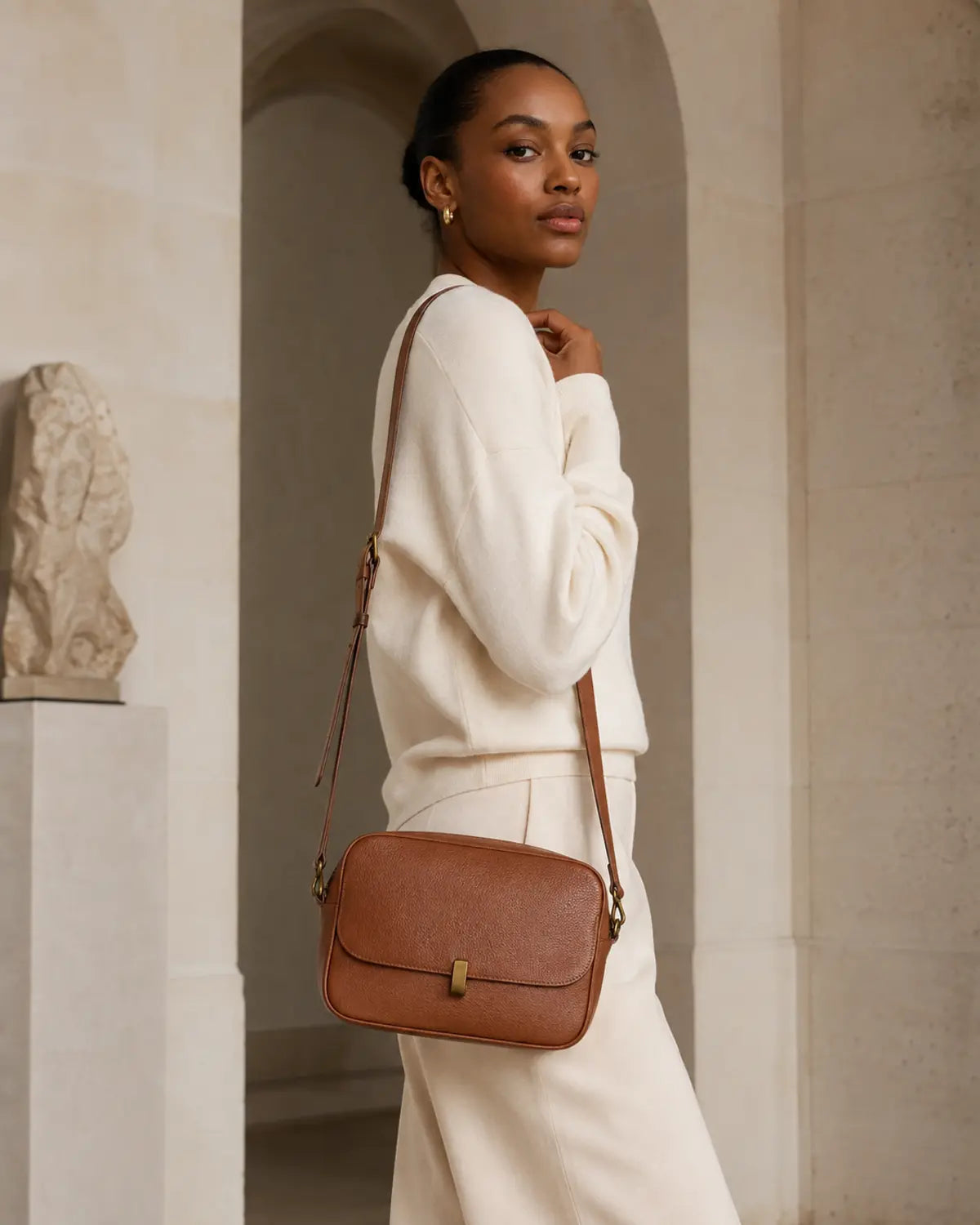 Adult model carrying the original Wolfoco Avenue cognac compact leather crossbody